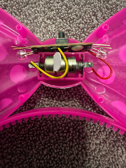 ABC Trading toy recall image showing exposed battery mechanism inside pink bow toy headband