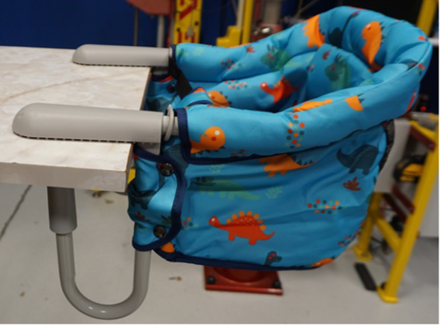 PandaEar portable hook-on chair recall showing blue dinosaur print baby chair attached to a table
